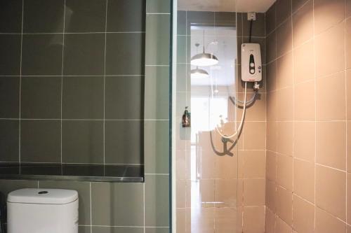 a shower in a bathroom with a toilet at Homesuite' Home at Aeropod SOVO in Kota Kinabalu