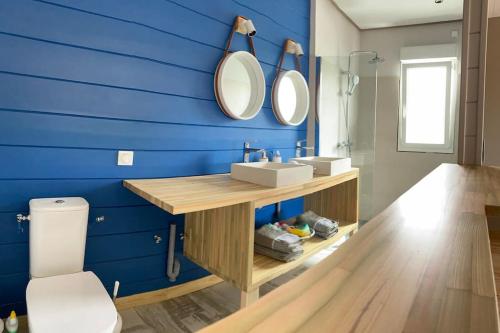 a blue bathroom with a sink and two mirrors at villa faula in Le Vauclin