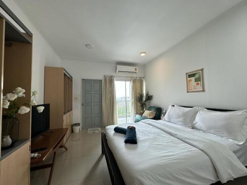 パックレにあるSTAYDII serviced residence Chaengwattanaのベッドルーム(白い大型ベッド1台、デスク付)