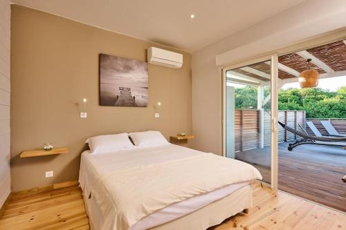 a bedroom with a large bed and a balcony at villa faula in Le Vauclin