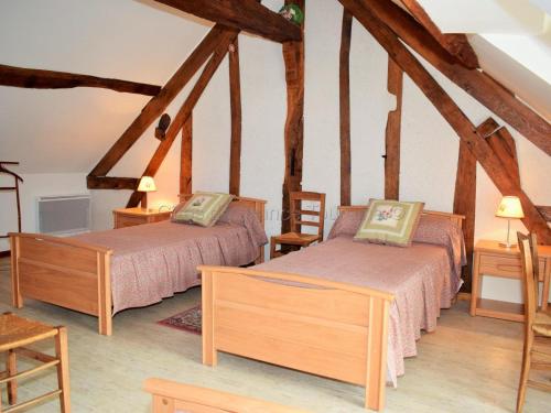 two beds in a room with wooden beams at Maison de caractère avec jardin, climatisation et vélos près d'Amboise - FR-1-381-357 in Cangey