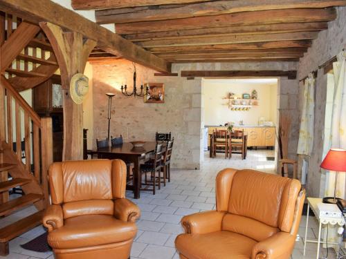 - un salon avec des fauteuils en cuir et une salle à manger dans l'établissement Charmante maison restaurée avec jardin, fibre optique et tout inclus, proche village pittoresque - FR-1-381-327, à Crissay-sur-Manse