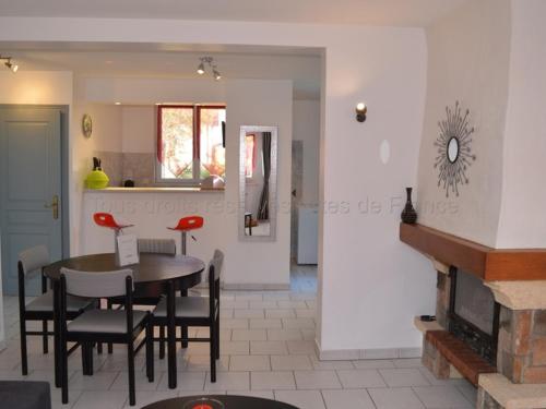 une salle à manger avec une table et des chaises et une cheminée dans l'établissement Gîte charmant avec jardin clos près d'Amboise - Équipé pour familles et jeunes enfants - FR-1-381-377, à Cangey