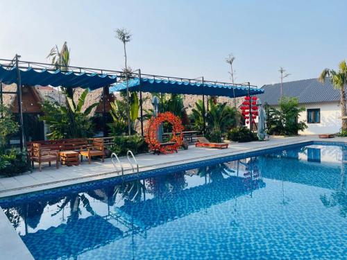 - une piscine avec une table et des chaises à côté dans l'établissement Tamcoc Metoo Bungalow 2, à Ninh Binh