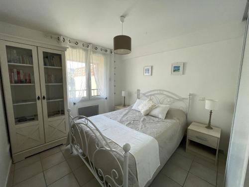 a white bedroom with a bed and a window at Appartement confortable au centre de Banyuls, à 300 m de la plage, idéal pour 4 personnes - FR-1-309-5 in Banyuls-sur-Mer