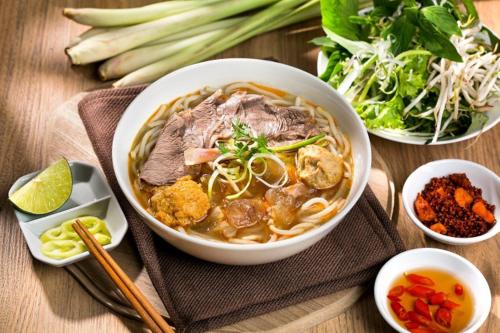 a bowl of soup with meat and vegetables on a table at Luu Ngai Condotel Quy Nhon in Quy Nhon