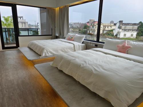 2 camas en una habitación con ventanas grandes en Jojolai Villa, en Wujie