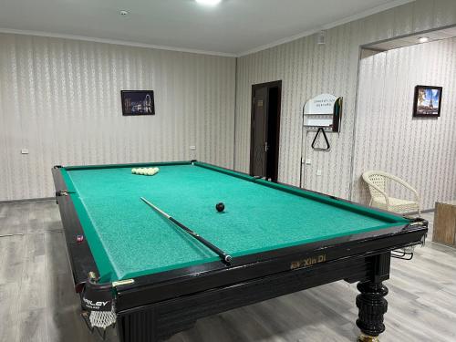 a pool table in a room with a green at Garden Plaza Bukhara in Bukhara