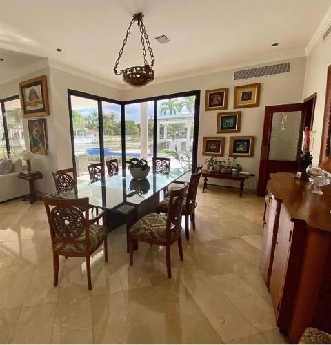 a dining room with a glass table and chairs at Casa alquiler en urbanización El Rio in Guayaquil