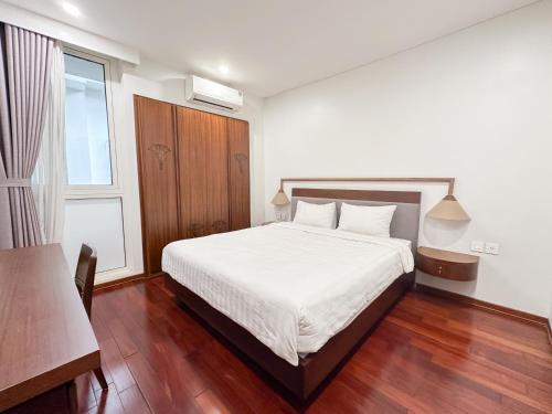 um quarto com uma grande cama branca e uma janela em Nikomix - SAKAMOTO II Apartment - 2 Bedroom 60m2 em Hanói