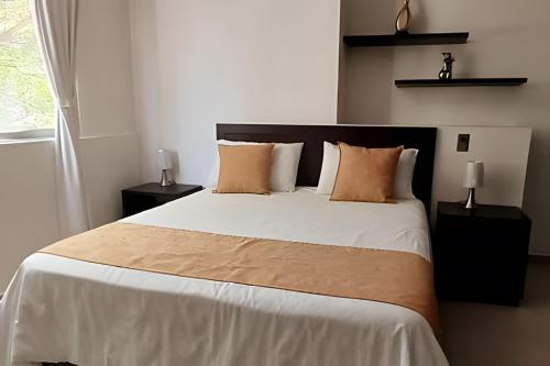 um quarto com uma cama grande e 2 mesas de cabeceira em 304 Moderno Aparta-Suite en Versalles Tipo Loft - Cali Tower Suites & Lofts em Cali