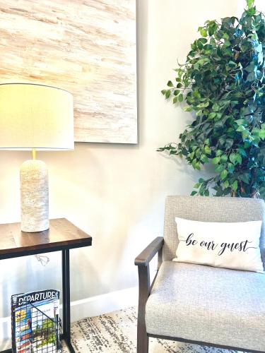 a living room with a chair and a table with a lamp at 2 mins to Downtown Atlantic Ave-3 mins to Beach-600mbps-BBQ-Fenced Yard in Delray Beach