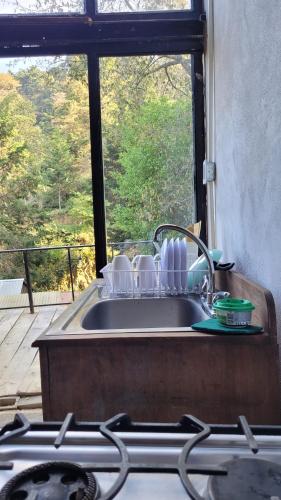 a kitchen sink with a view of a window at Cabaña privada in San Lucas Sacatepéquez