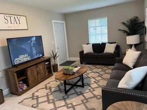uma sala de estar com uma televisão e um sofá em Spacious Home Near Downtown & the Beach em Delray Beach