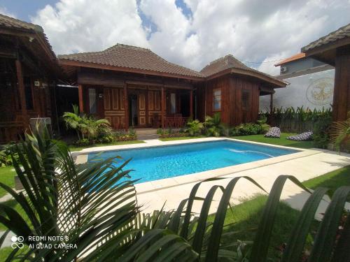 une maison avec une piscine dans la cour dans l'établissement ASHVATTHA VILLA Canggu, à Canggu