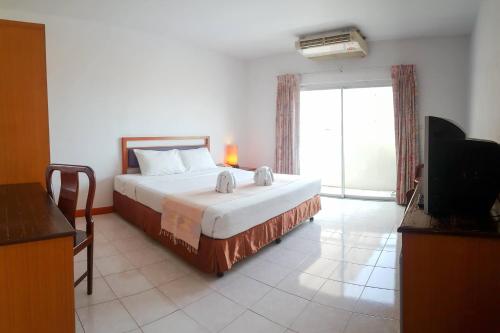 una camera con un letto e una grande finestra di Eastiny Bella Vista Hotel a Centro di Pattaya