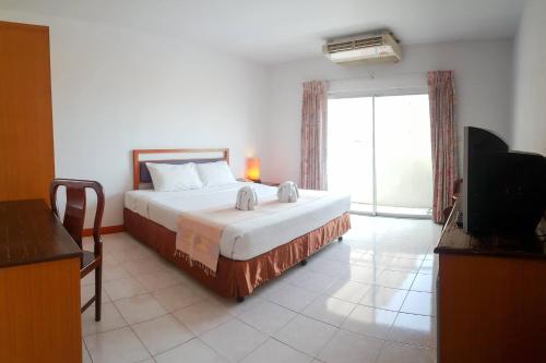 a bedroom with a bed and a large window at Eastiny Bella Vista Hotel in Pattaya Central