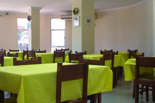 una sala con tavoli e sedie con tovaglia verde di Hotel New Tokyo a Capitão Poço