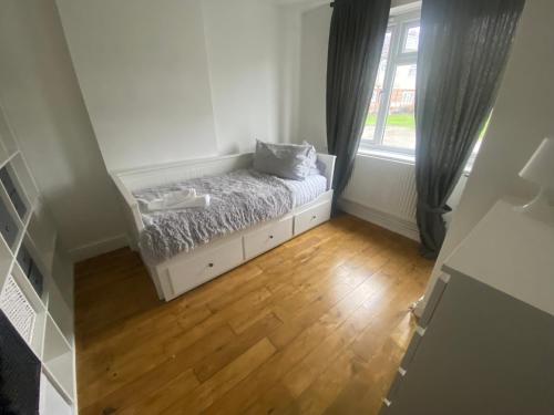 a small bedroom with a bed and a window at Maple Lodge in South Norwood
