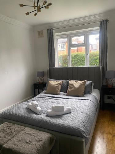 a bedroom with a bed with two towels on it at Maple Lodge in South Norwood