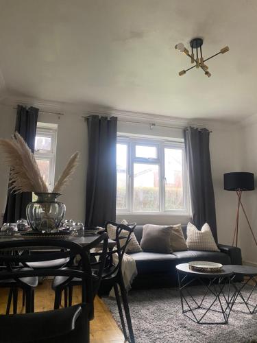 a living room with a couch and a table at Maple Lodge in South Norwood