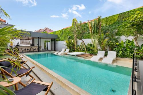 una piscina all'aperto con sedie e un piscina con piscina per il nuoto. di Alex Villas Complex N3 a Canggu