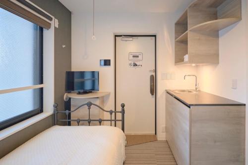 a small bedroom with a bed and a sink at HJ PLACE TAKANAWA in Tokyo