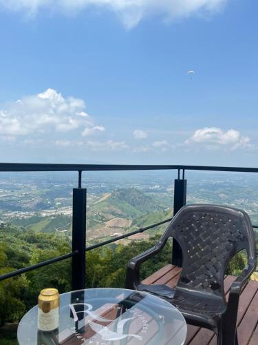 a table and a chair on a balcony with a view at Glamping Ríos Voladores Pereira in Pereira