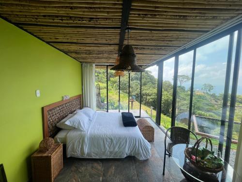 a bedroom with a bed and a large window at Glamping ríos voladores pereira in Pereira