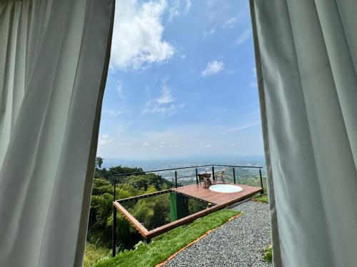 a room with a balcony with a view of the ocean at Glamping Ríos Voladores Pereira in Pereira