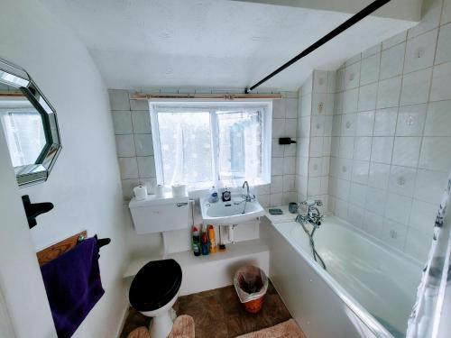 a bathroom with a sink and a toilet and a tub at Stay Sleep Rest Heeley, Sheffield in Heeley