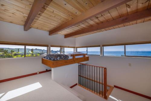 a bedroom with a bed in a room with windows at Unmatched Ocean Beach and Mountain Views Family-Friendly Retreat in Moss Beach