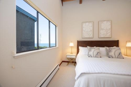 a bedroom with a bed and a large window at Unmatched Ocean Beach and Mountain Views Family-Friendly Retreat in Moss Beach