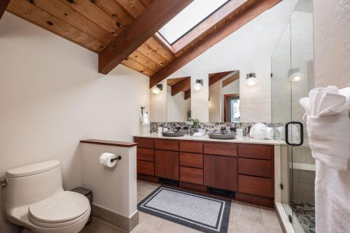 a bathroom with a toilet and two sinks at Unmatched Ocean Beach and Mountain Views Family-Friendly Retreat in Moss Beach