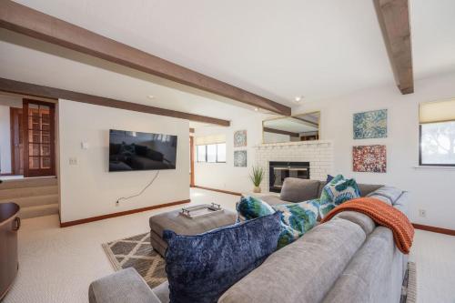 a living room with a couch and a tv at Unmatched Ocean Beach and Mountain Views Family-Friendly Retreat in Moss Beach