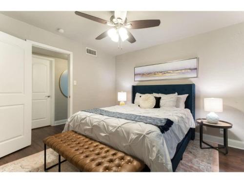a bedroom with a large bed with a ceiling fan at The Flamingo 102 l Pool I 65 Smart TV I Sleeps 5 in Austin
