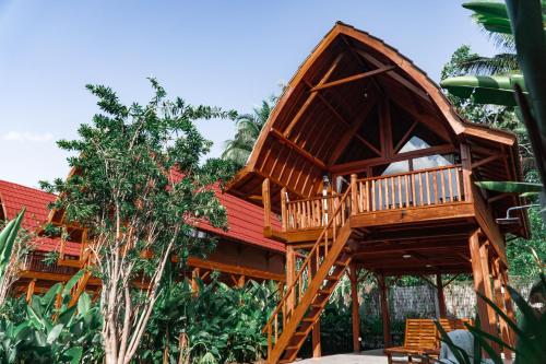 une cabane dans les arbres avec une terrasse dans la forêt dans l'établissement Kusfarm Bali, à Selemadeg