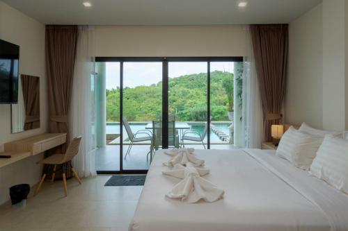 a bedroom with a large white bed and a balcony at Viva Montane Hotel Pattaya in Pattaya South