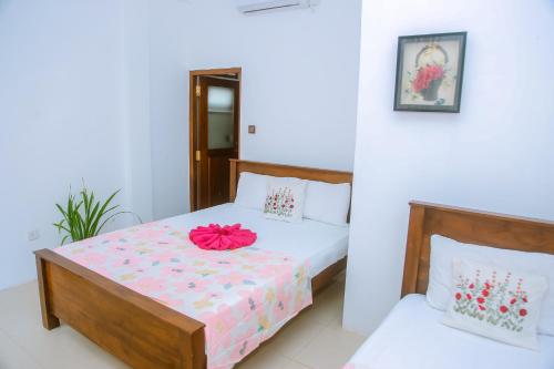 a bedroom with a bed with a pink flower on it at T20 Mirissa in Mirissa