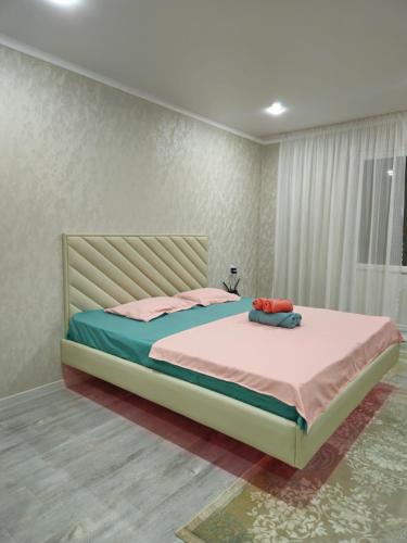 1 dormitorio con 1 cama grande en una habitación en Luxeroom, en Semey