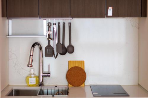a kitchen with a sink and utensils on the wall at Wecostay Gangnam in Seoul