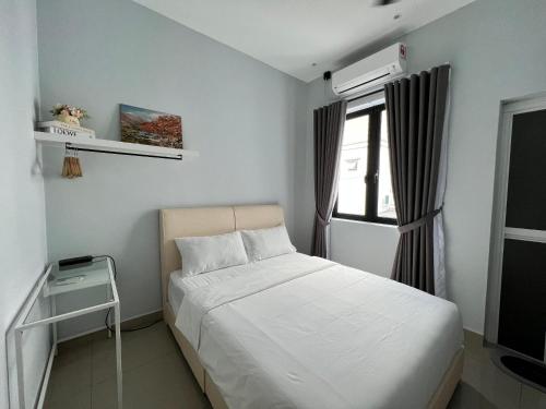 a bedroom with a white bed and a window at Luxe J Homestay in Taiping