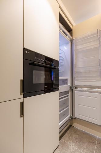 a kitchen with white cabinets and a black oven at Wecostay Gangnam in Seoul