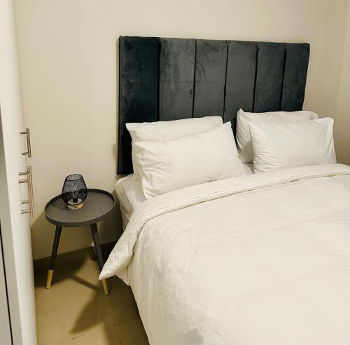 a bed with a black headboard and a side table at Mkhonto-PR The Millenial Durban, Umhlanga in Durban