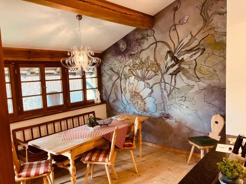 a dining room with a table and a wall mural at Ferienwohnung Schankwirtschaft Wohlfart in Pfronten