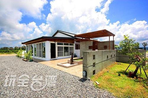a house on a gravel road in front at Kenting Xia Ye B&B in Hengchun