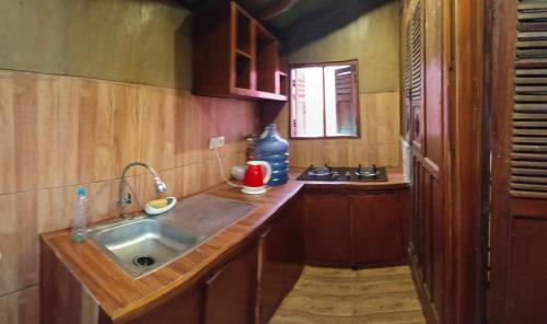 a small kitchen with a sink and a counter at Omah kayu bromo in Ngadisari