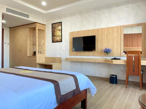 a bedroom with a bed and a flat screen tv at Rex hotel An Nhon 