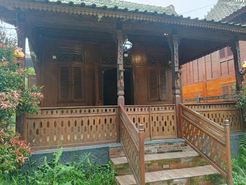 a wooden porch of a house with a wooden railing at Omah kayu bromo in Ngadisari
