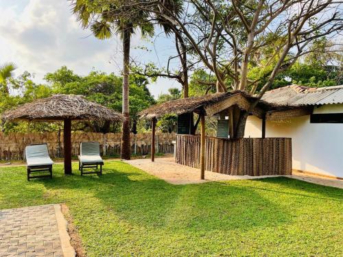 two chairs and umbrellas in a yard at 108 Palms Beach Resort in Trincomalee
